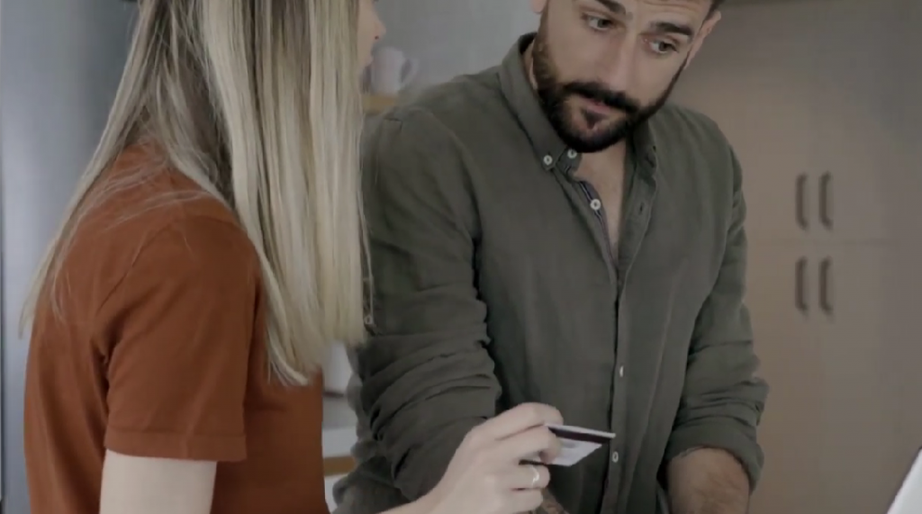 Woman explaining details to man with card in hand