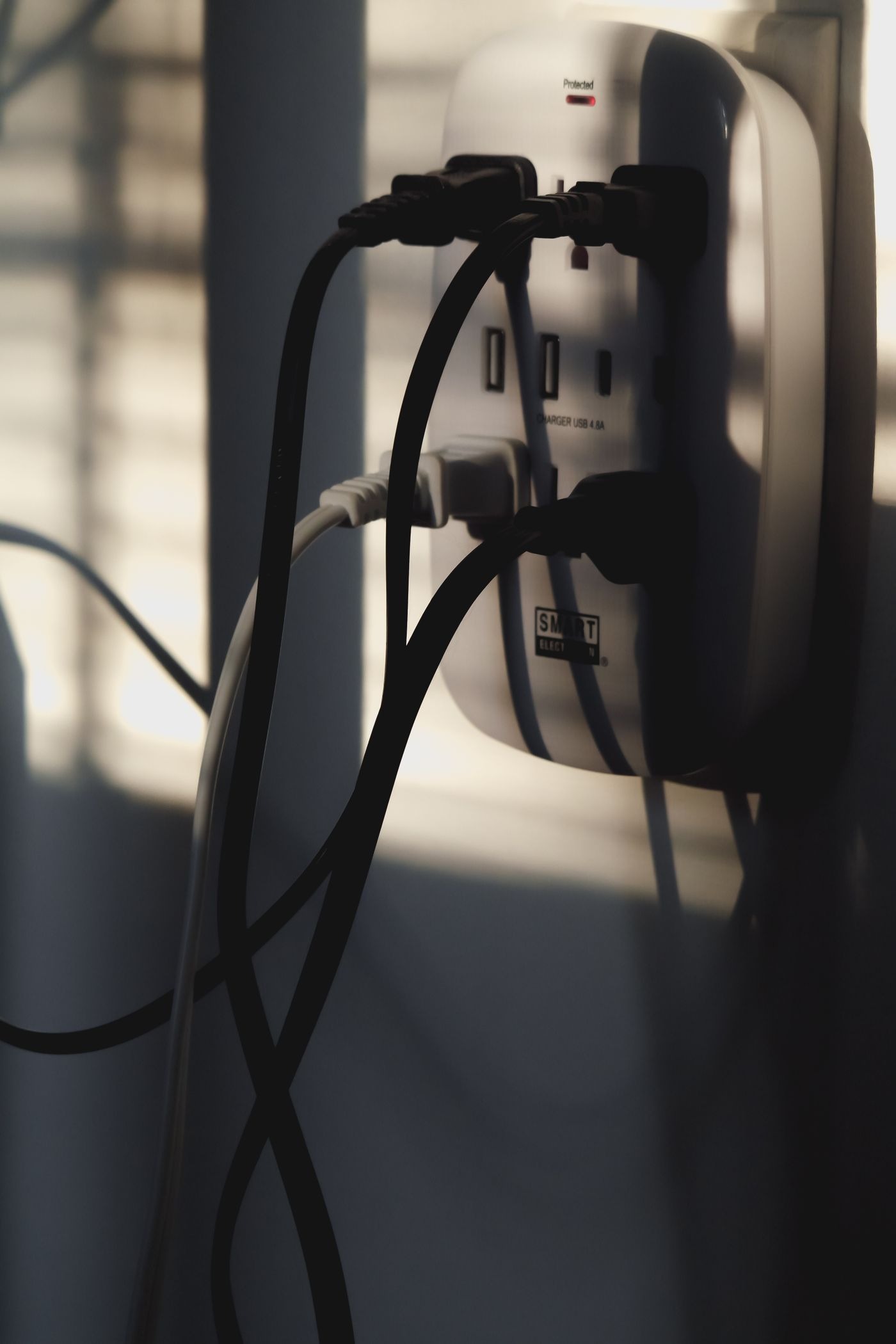 Stock photo of power cords plugged into a wall outlet, not a listed product