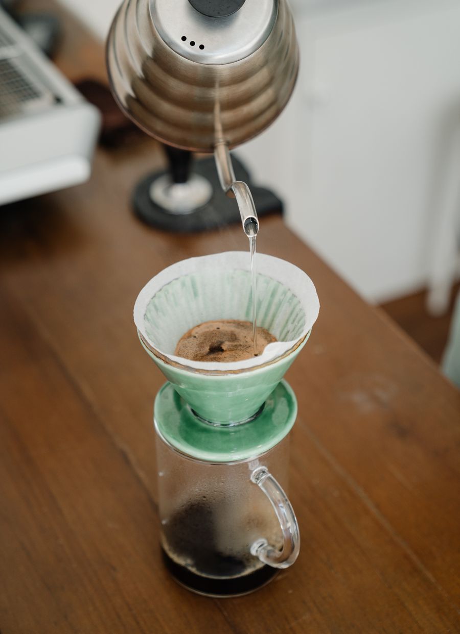 Water pouring from a gooseneck kettle into a pour-over dripper