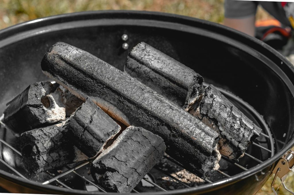 Charcoal briquettes on the grate of a kettle grill
