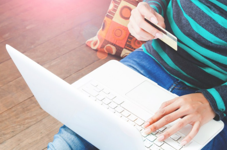 close up of female with laptop computer and credit card at home