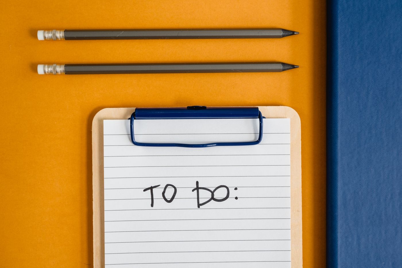 Stock photo of a to-do list on a clipboard with two pencils, not a listed product