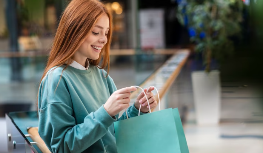 Redhead woman looking inside shopping bag
