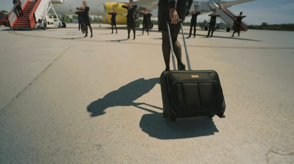 flight attendant with briefcase on her way to a vueling airlines plane