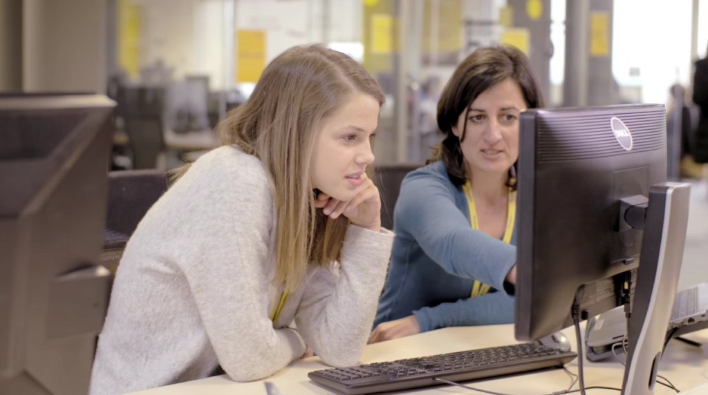 two women sitting at a computer