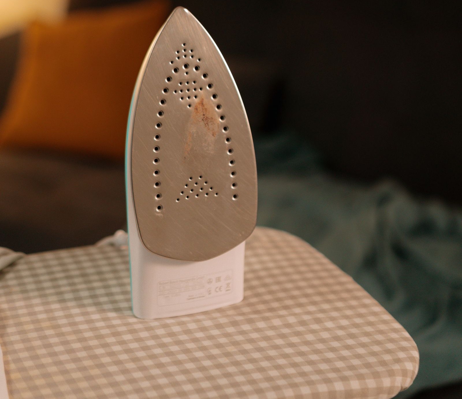 Clothes iron resting on a padded ironing board