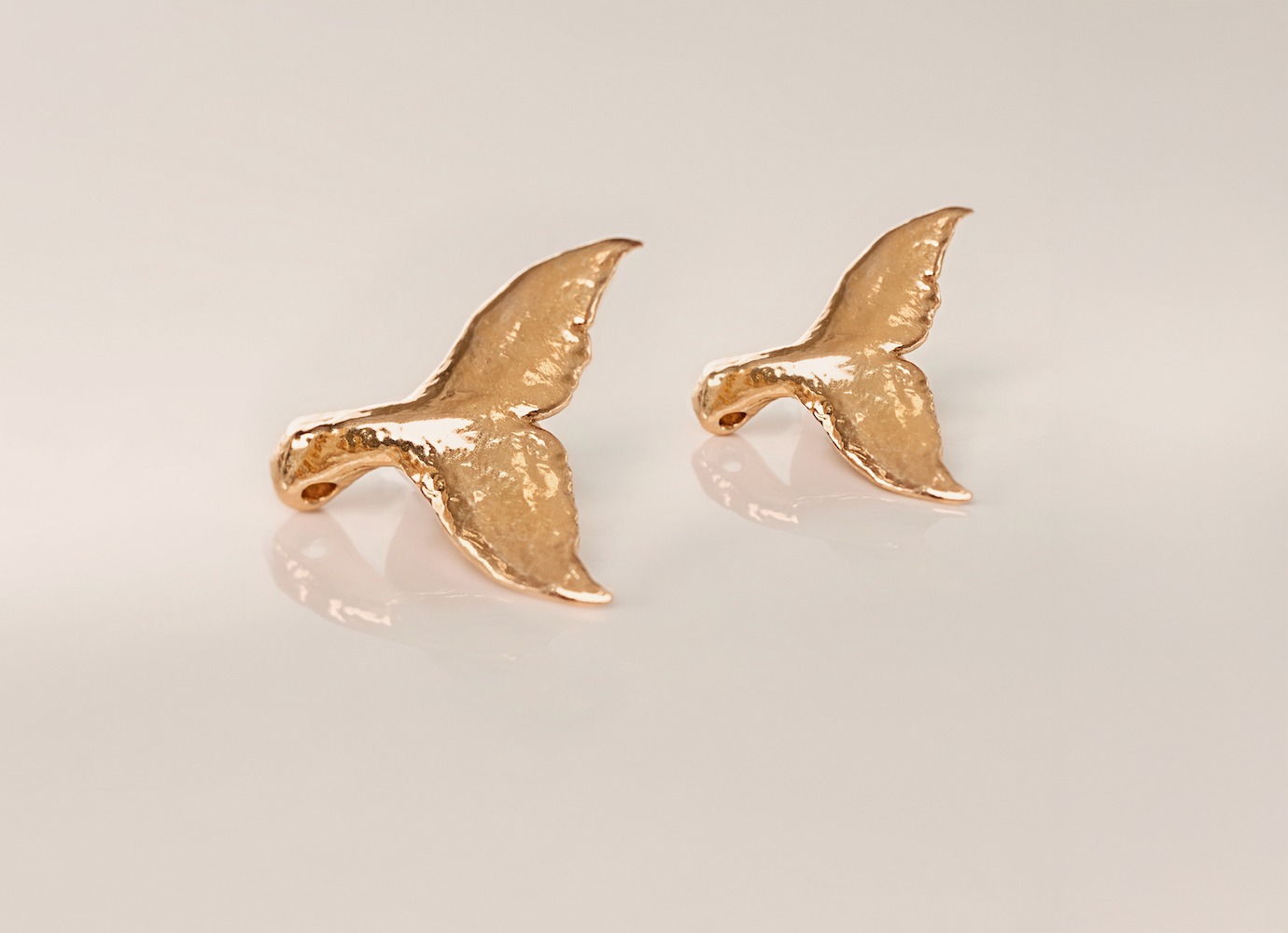 Rhodes24K whale tail pendants in .9999 gold, small and large