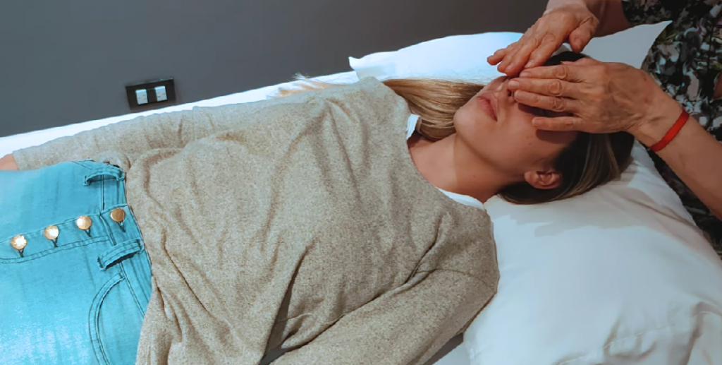 woman lying on a stretcher in a reiki session