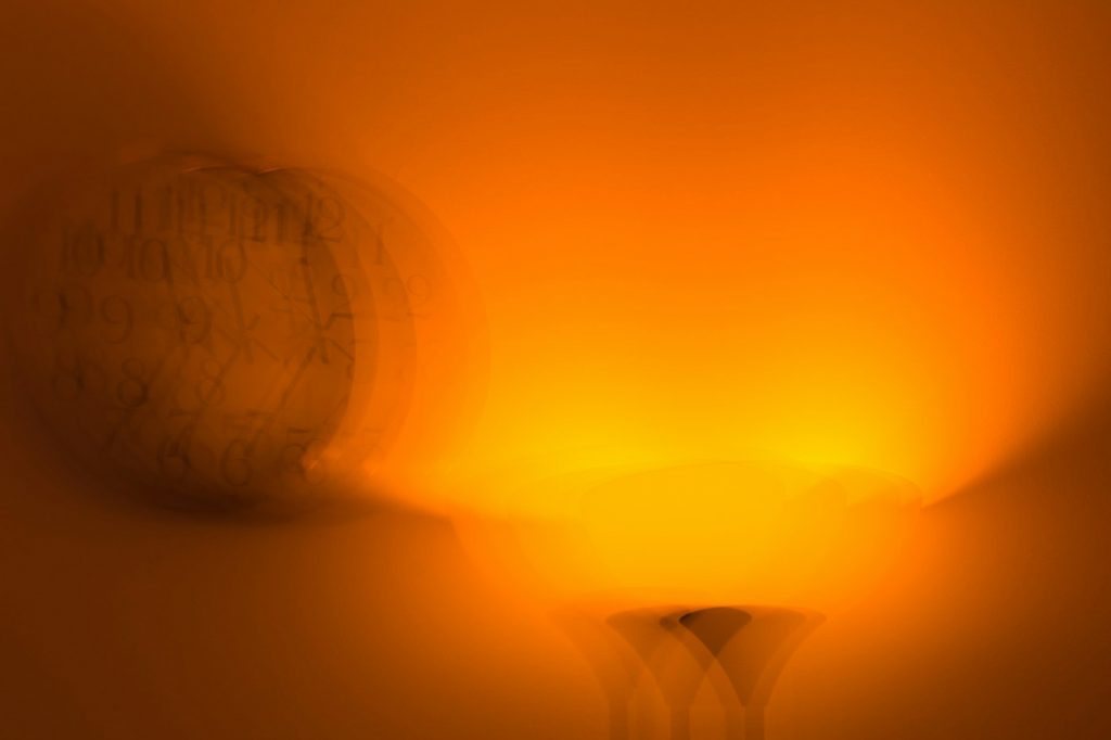A soft orange night light glow spreading across a wall in a dark room