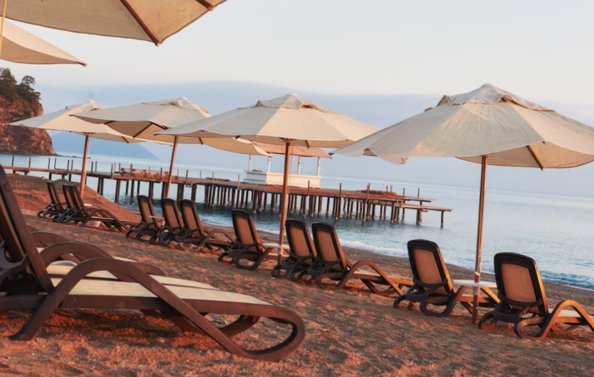 scenic view of private sandy beach on the beach with sun beds against the sea and mountains. amara dolce vita luxury hotel. resort. tekirova-kemer. turkey

