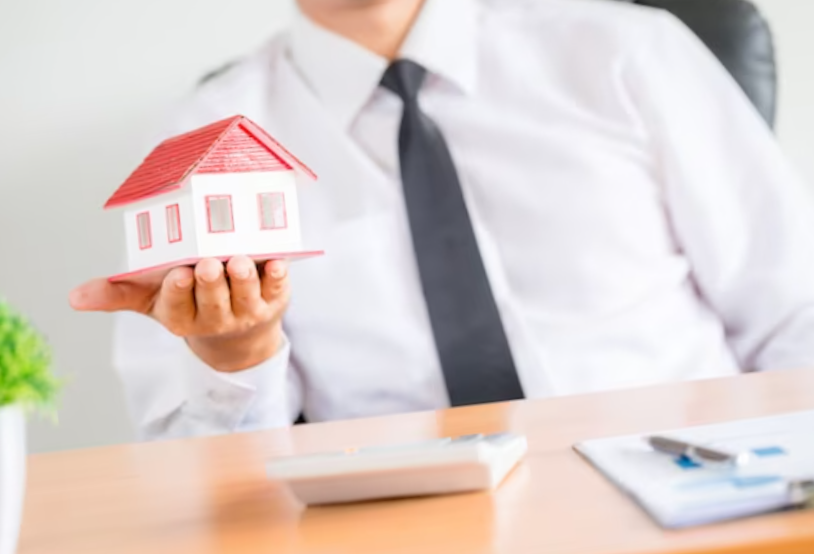 human hands holding model of dream house.