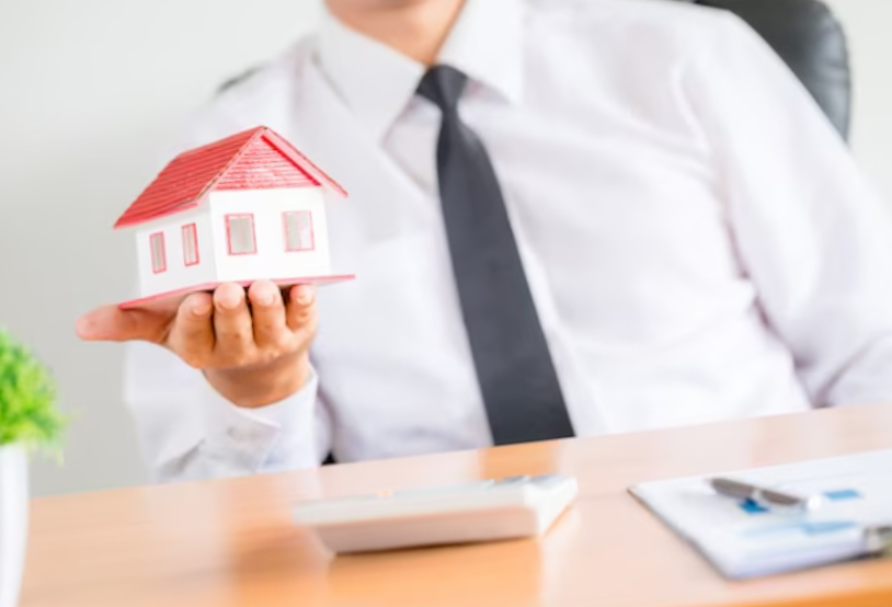 human hands holding model of dream house.
