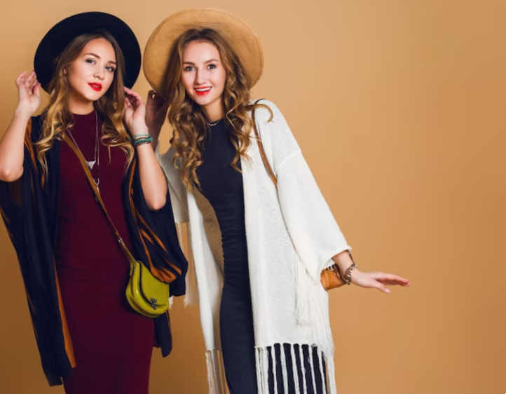 Fall studio shot of two models with blond wavy hairstyle in wool and straw hat wearing striped poncho