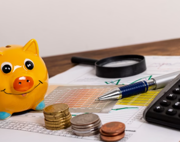 stationery items and piggy bank with money
