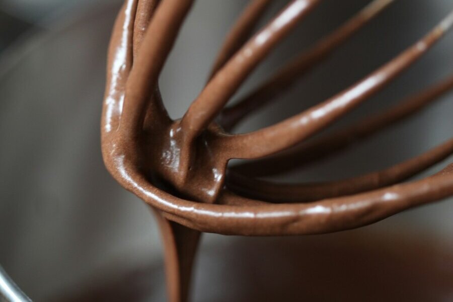 Chocolate batter being mixed in a metal bowl