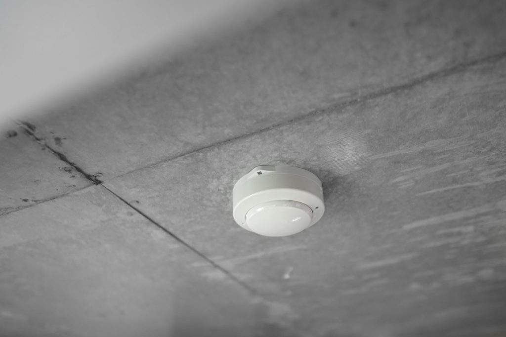 White smoke alarm mounted on a ceiling