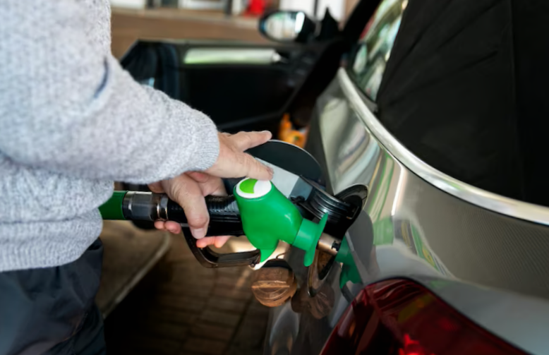 close up hand pumping gas in car
