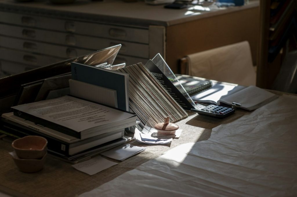 Paper and supplies on a desk before organizing; free Unsplash photo