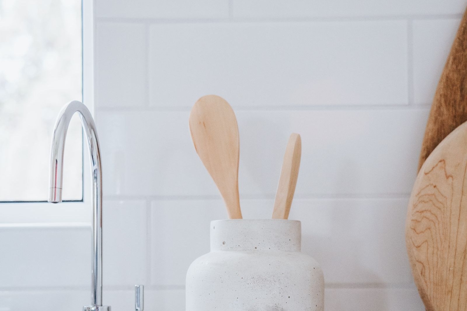 Wooden spoons in a jar by a kitchen sink
