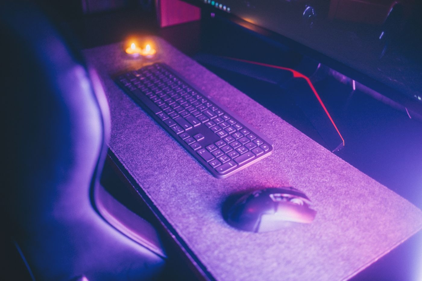 Stock photo of a computer mouse on a desk pad next to a keyboard, not a listed product