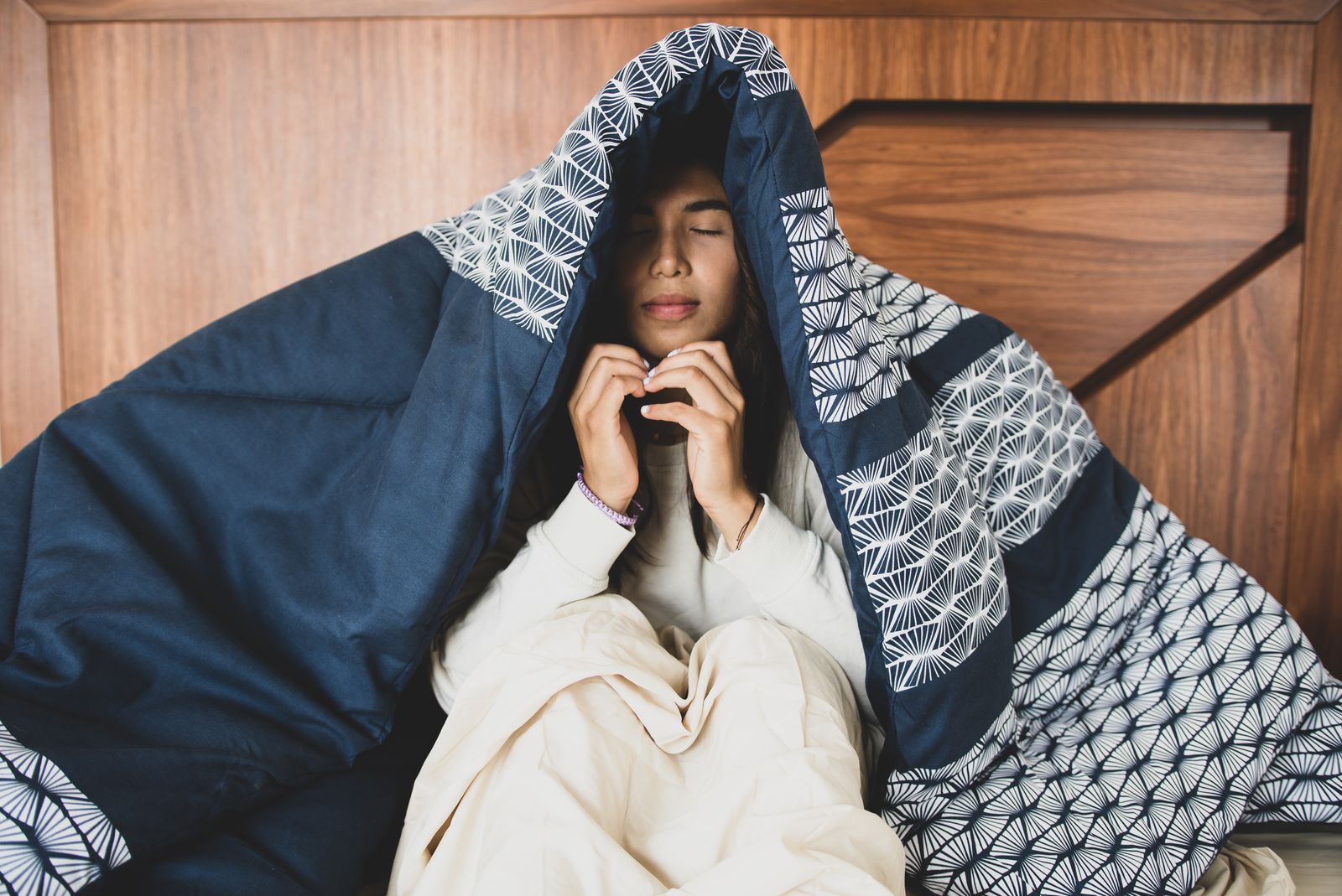 Person wrapped up in a heavy patterned blanket
