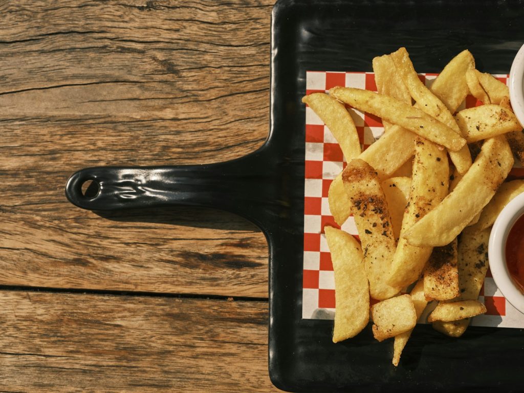 Crispy seasoned potato wedges on a serving board