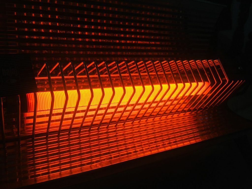 Glowing orange heating element of an electric heater in a dark room