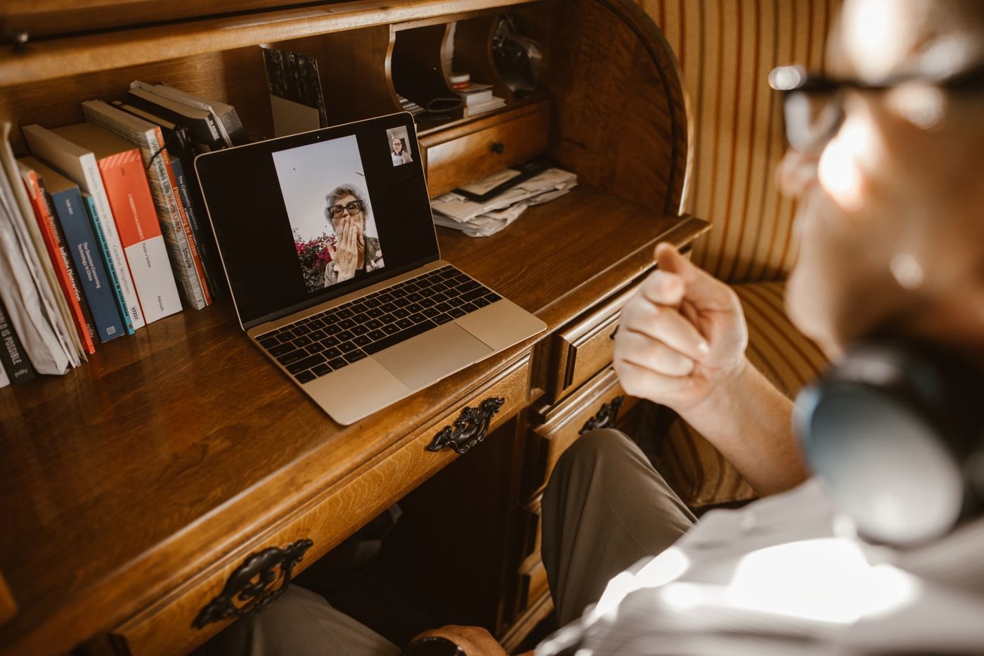 Stock photo of a laptop on a wooden desk showing a video call, not a listed product